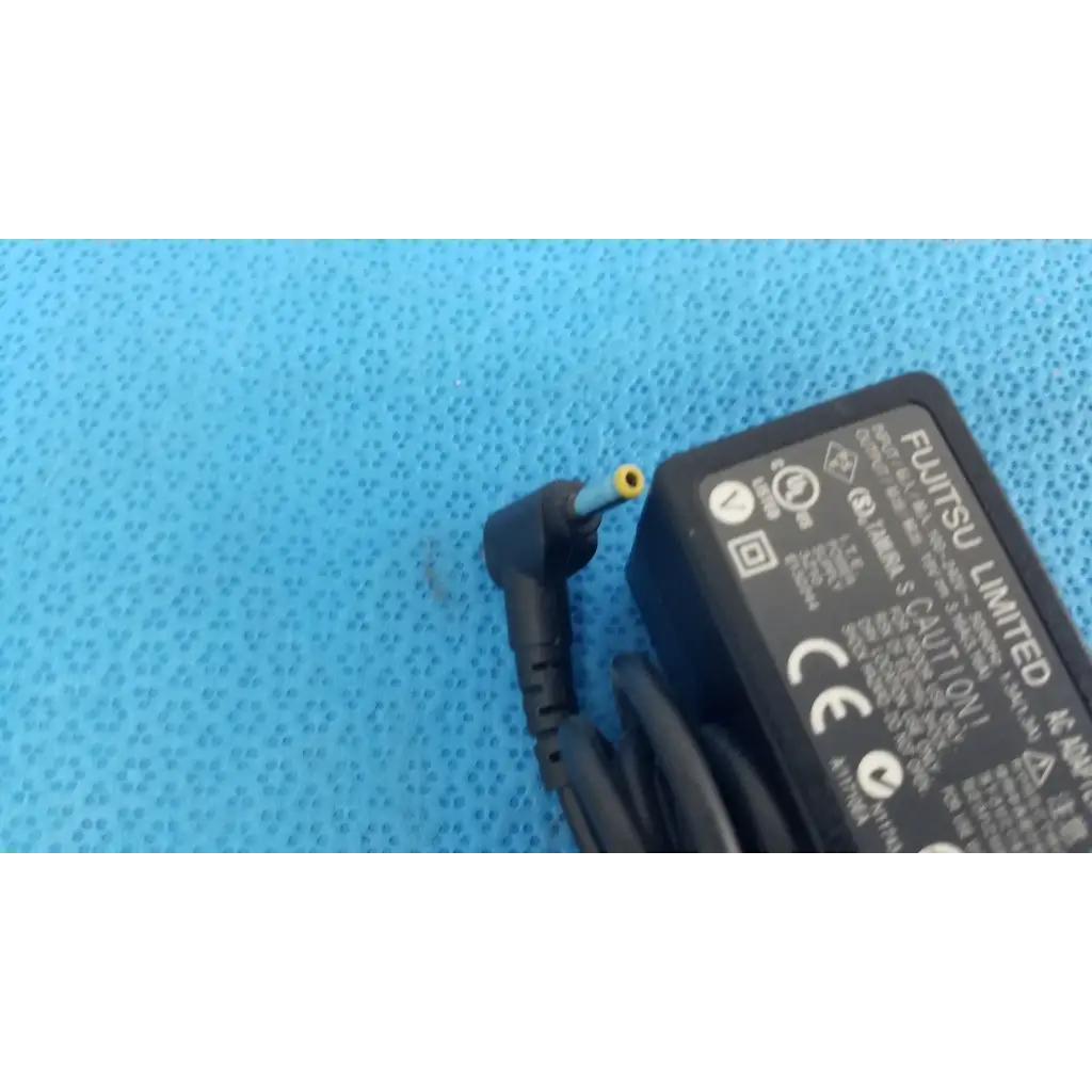 Black plastic fujitsu ac adapter power supply 19v 3.16a with coiled cord and yellow-tipped angled connector
