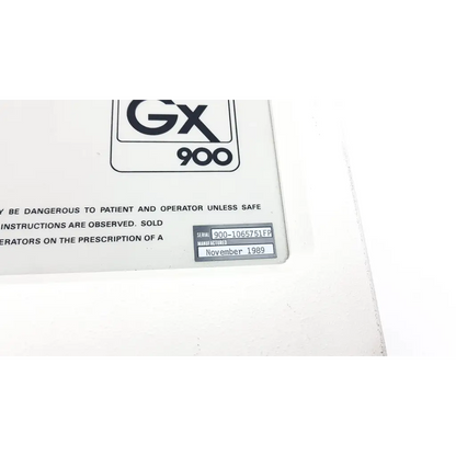 White plastic label with black text and gx 900 logo on the back of a gendex gx 900 wall mount dental xray unit
