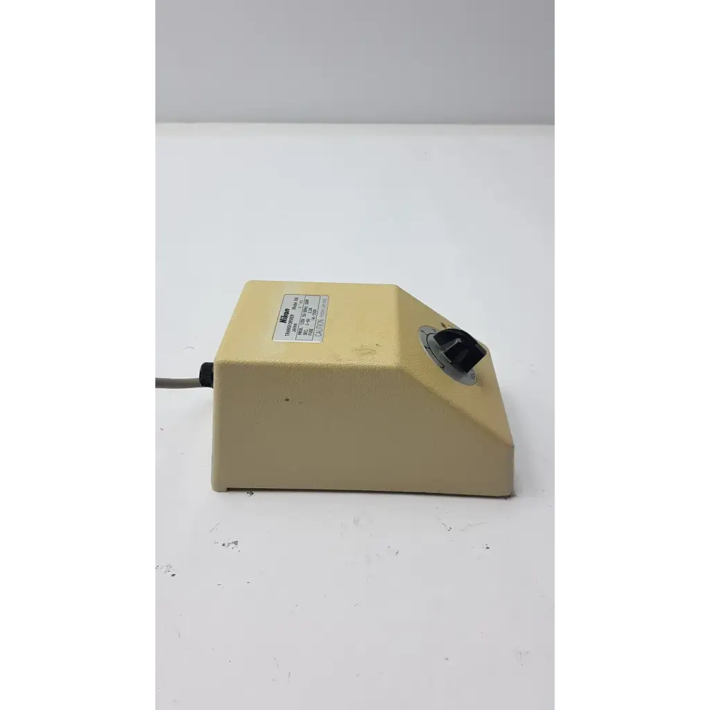 Beige rectangular genuine nikon transformer xn with black rotary knob and gray power cord made in japan