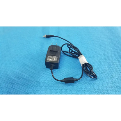 Black plastic globtek gt-41052-1509 adapter charger with coiled power cord and white band securing the cable