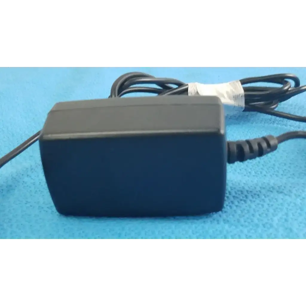 Black plastic gt-41052-1509 adapter charger with coiled cord and white label wrapped around cable power adapter