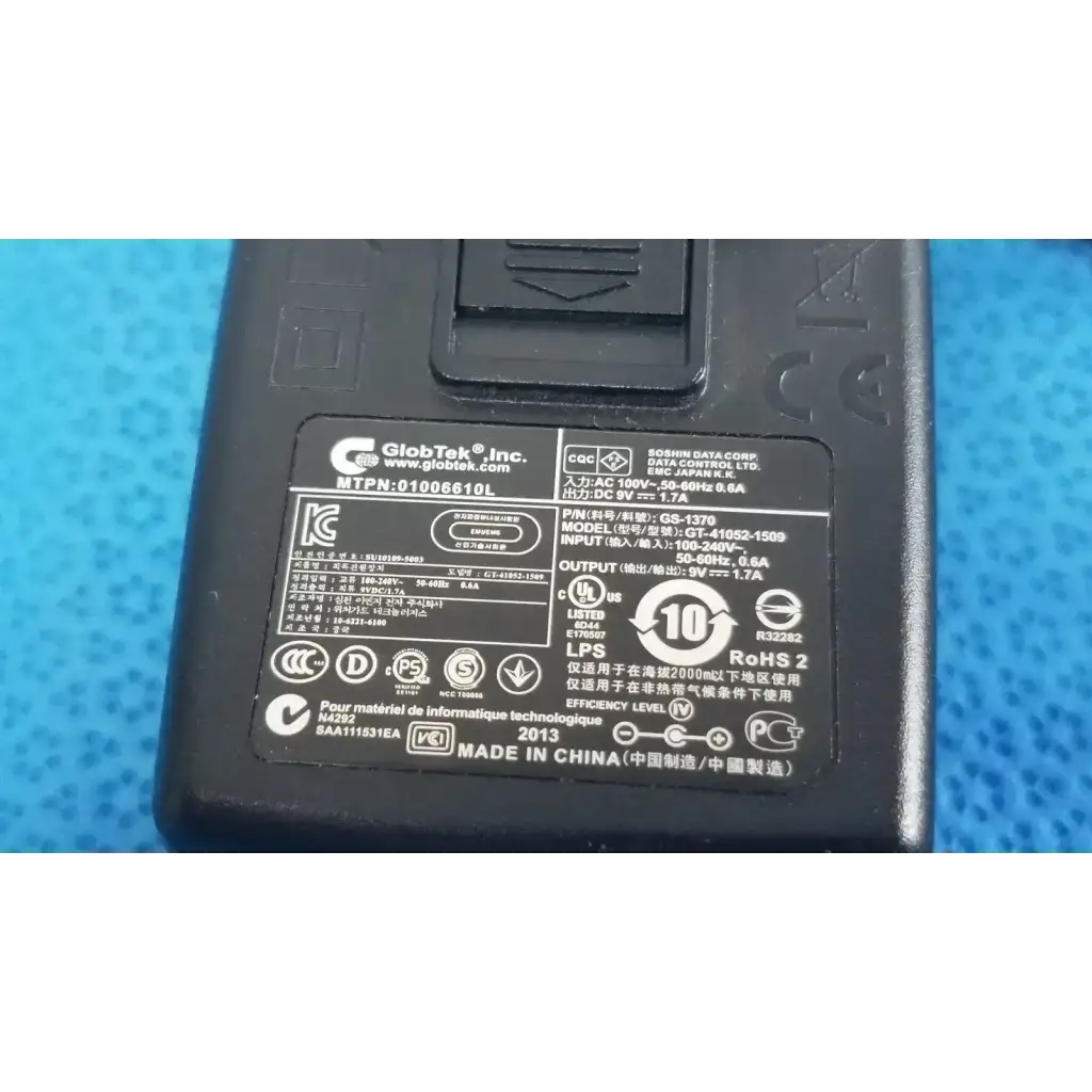 Black plastic power adapter charger gt-41052-1509 with technical specifications label and certification marks on the back side