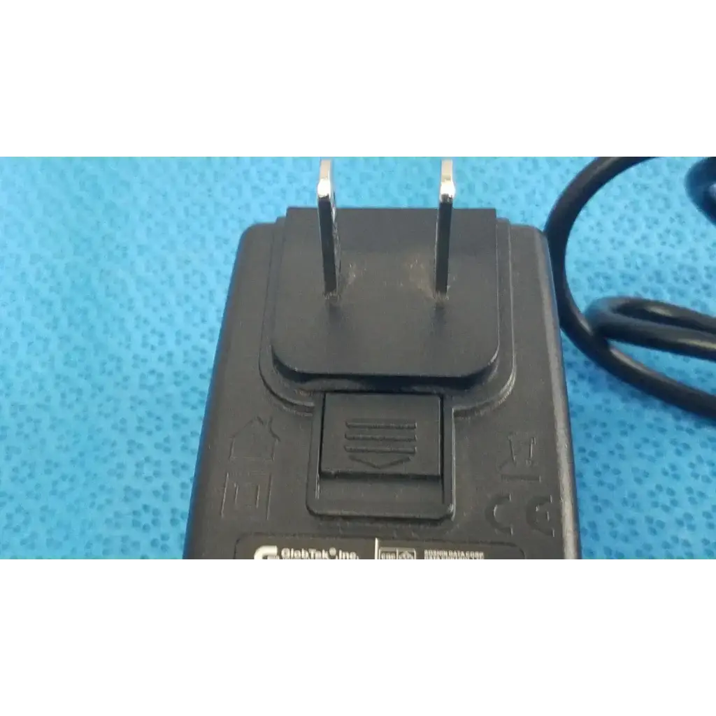 Black plastic power adapter charger globtek gt-41052-1509 with two prongs and coiled cable for reliable power supply