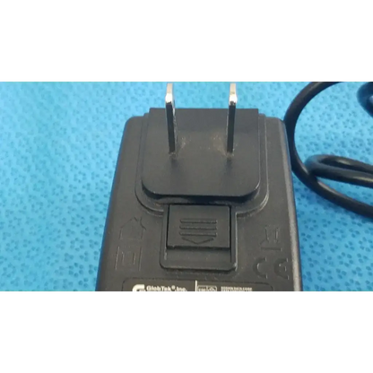 Black plastic power adapter charger globtek gt-41052-1509 with two prongs and coiled cable for reliable power supply