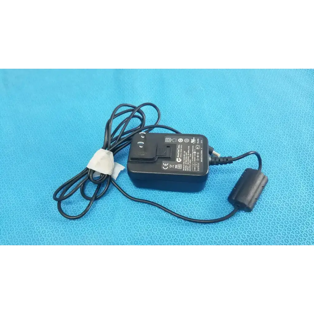 Black plastic Globtek GTM41060-1505 medical power supply with coiled cable and white band securing cord