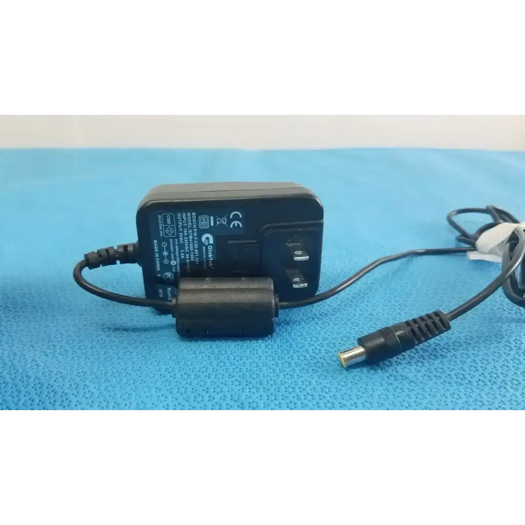 Black plastic medical power supply globtek gtm41060-1505 with coiled cable and cylindrical connector for medical power