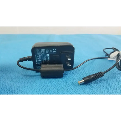 Black plastic medical power supply globtek gtm41060-1505 with coiled cable and cylindrical connector for medical power