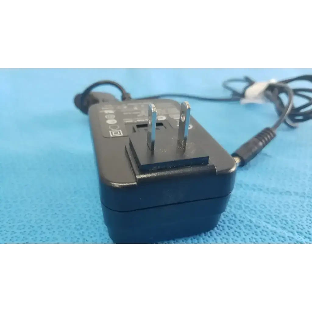 Black plastic globtek GTM41060-1505 medical power supply with silver prongs and coiled black power cord for medical power