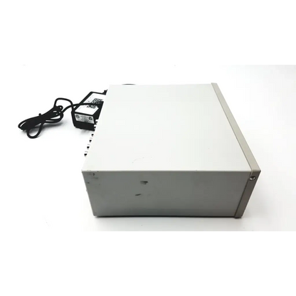 Gray rectangular grass 15lt physiodata 15a54 quad amplifier system with black power adapter and cord nearby