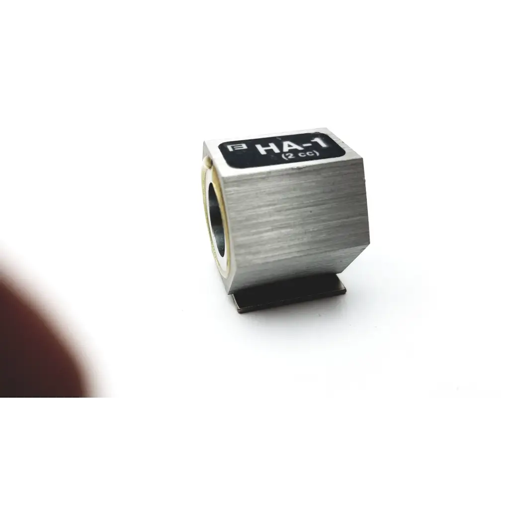 Silver brushed metal ha-1 2cc cylindrical component with black label and gold-colored inner ring is shown