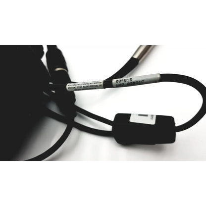 Black coiled cable with silver label and black connector attached to hand held ws137872 scanteam barcode scanner
