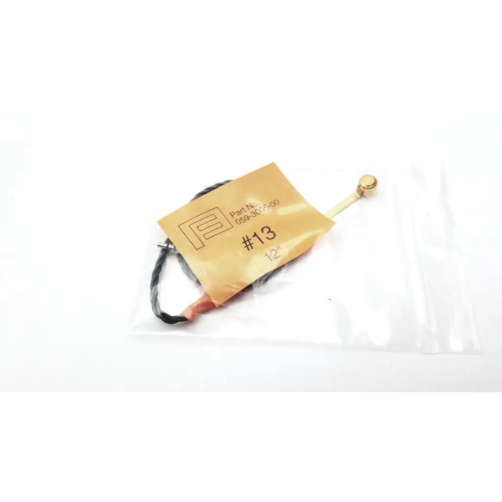 Hearing aid programming adapter with gold metal antenna black insulated wire and small spherical tip in clear plastic packaging
