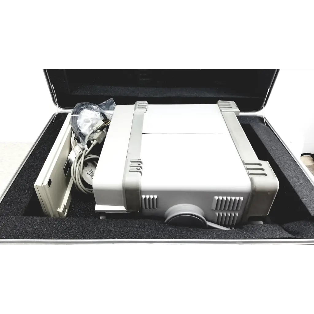 Gray and white fujifilm projector with ventilation grilles shown with hewlett packard optical time domain reflectometer and case
