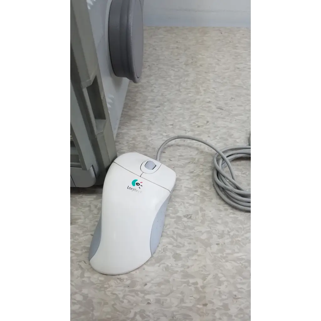 White and gray logitech mouse with curved ergonomic design shown with hewlett packard 8147 optical time domain reflectometer and case