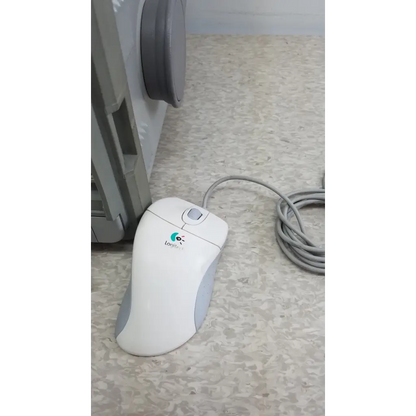 White and gray logitech mouse with curved ergonomic design shown with hewlett packard 8147 optical time domain reflectometer and case