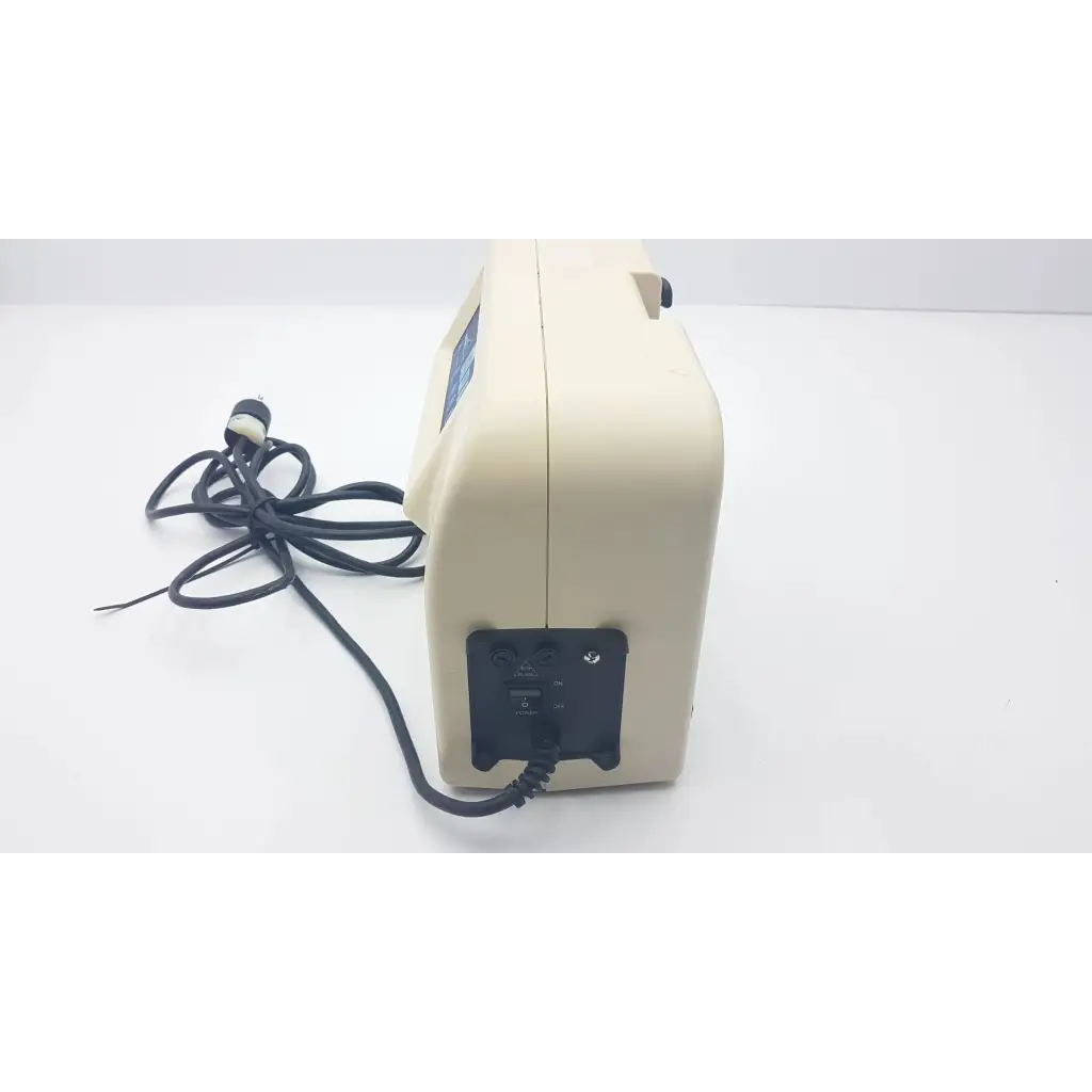 Cream-colored plastic synergy air elite air mattress pump with black power cord and control panel for air elite use