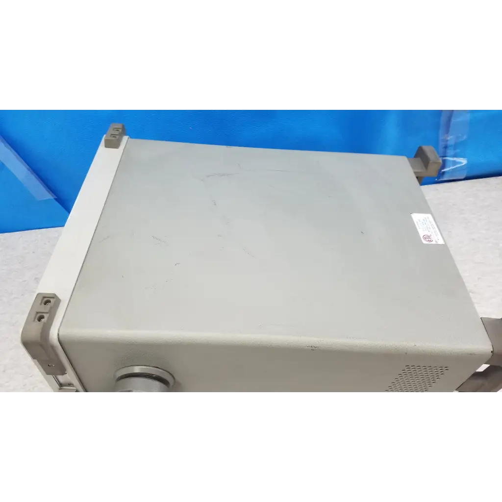 Gray metallic hewlett packard communications test set with rounded corners and ventilation grilles for rf testing