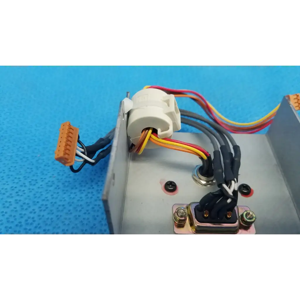 White plastic electrical connector with colored wires on metallic housing of topcon trc-nw6s data port interface panel