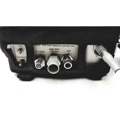 Backside of black impact instrumentation uni-vent 754 portable ventilator showing labeled oxygen air and gas ports