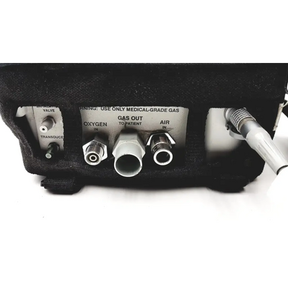 Black foam-lined back of impact instrumentation portable ventilator with labeled oxygen and air medical gas ports