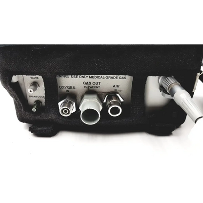 Black medical gas delivery device with labeled oxygen and air ports and metallic connectors on impact instrumentation uni-vent 754 portable ventilator back side