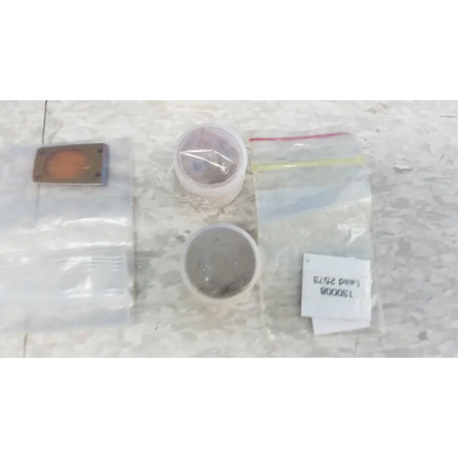 Two clear plastic bags including a small orange and silver object in the innov-x systems a-4000 s alpha handheld analyzer spectrometer kit