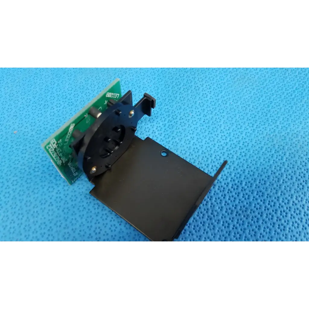 Black plastic and metal mounting bracket with green circuit board for internal fixation target in topcon trc-nw6s retinal camera
