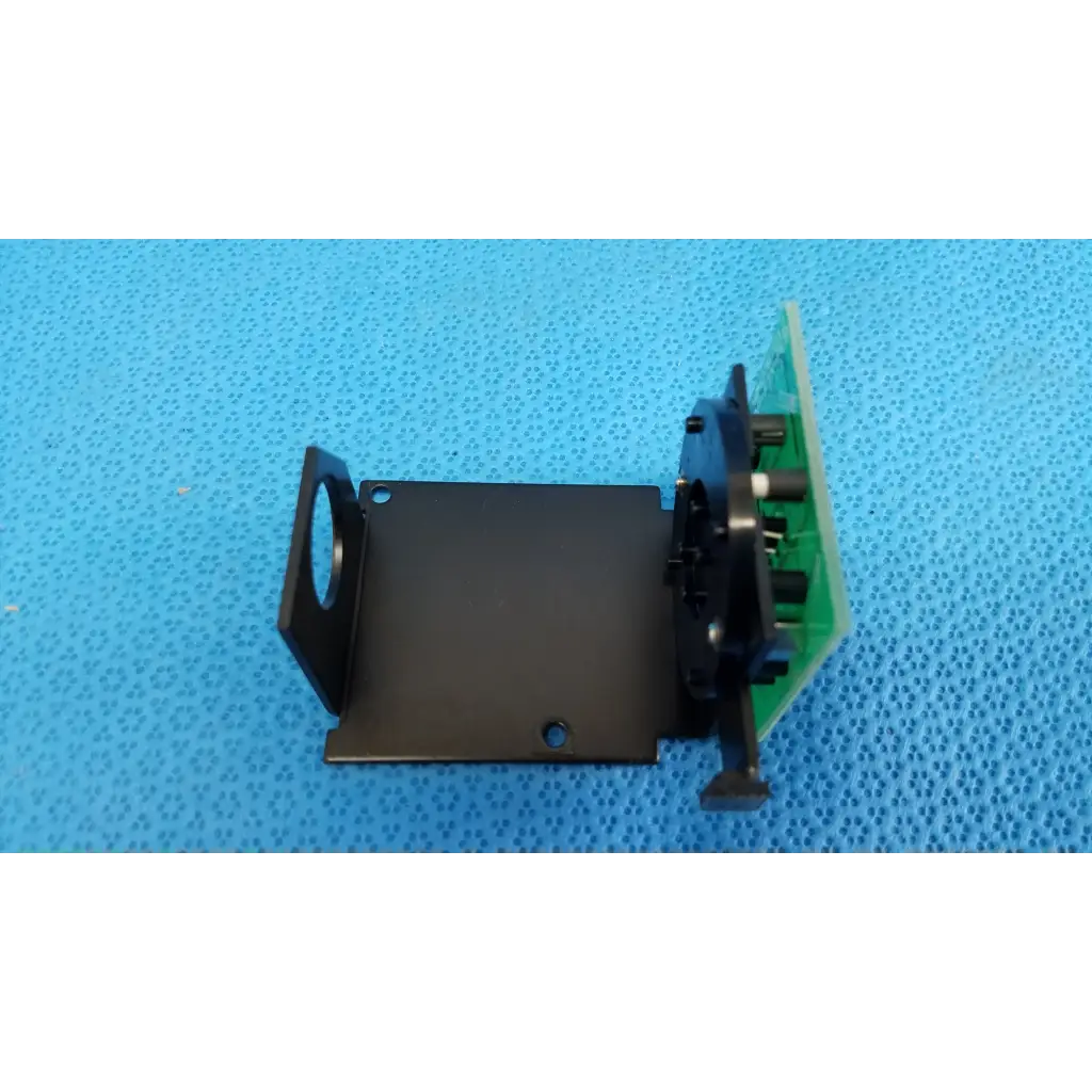 Black metal bracket with green circuit board and black plastic parts for internal fixation target in topcon retinal camera
