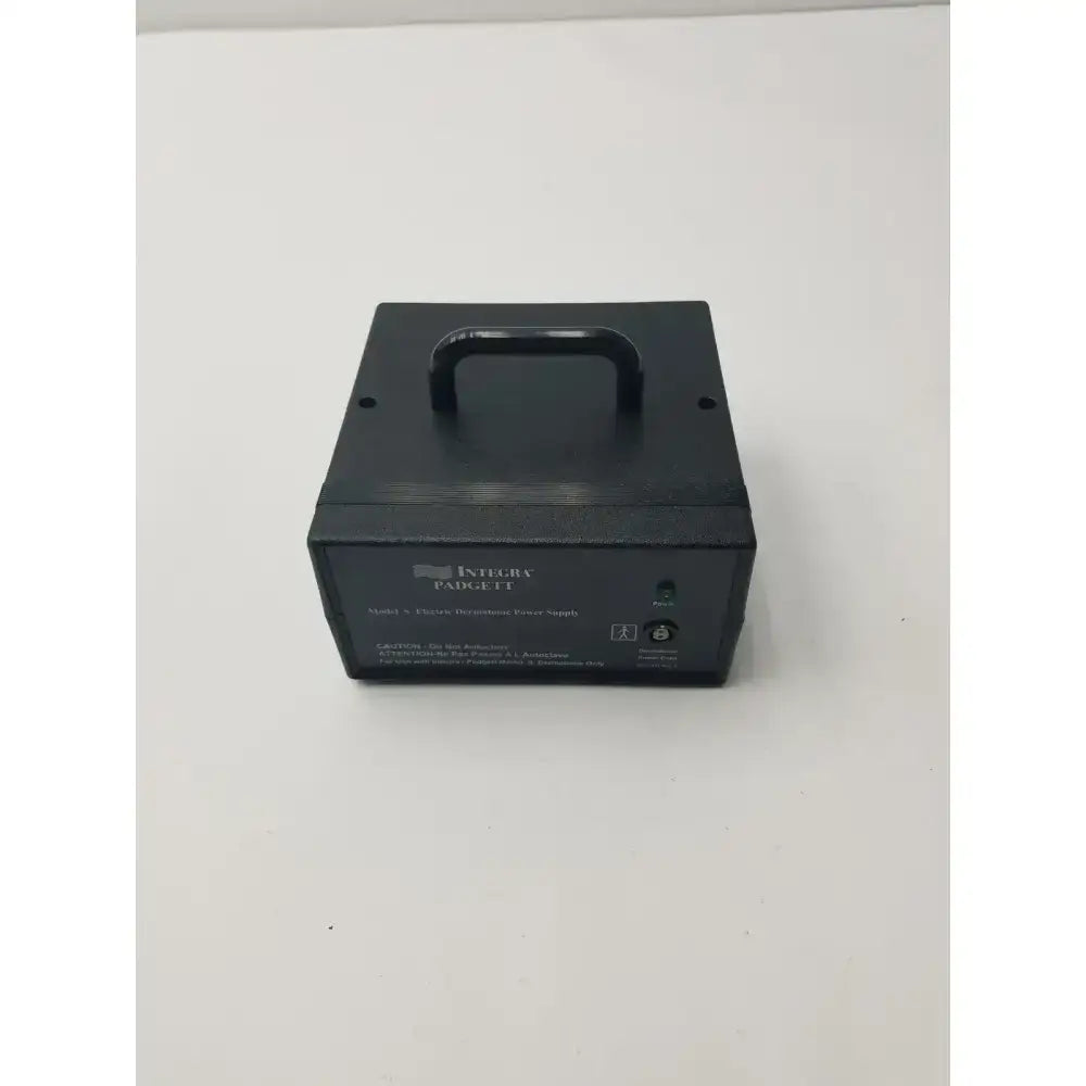 Black rectangular integra padc-ft dermatome power supply unit with top handle and labeled ports for electric dermatome use