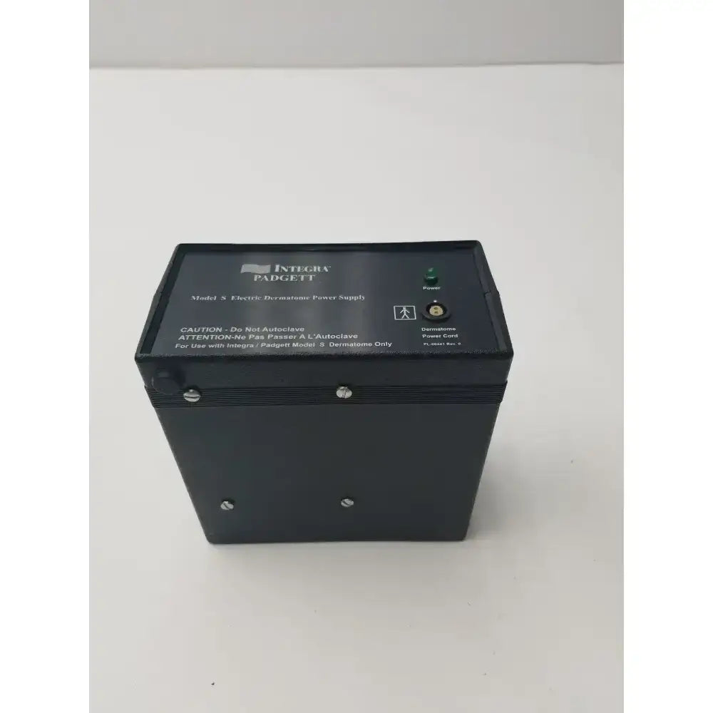 Black rectangular integra padgett model s electric dermatome power supply with green power indicator and labeled ports