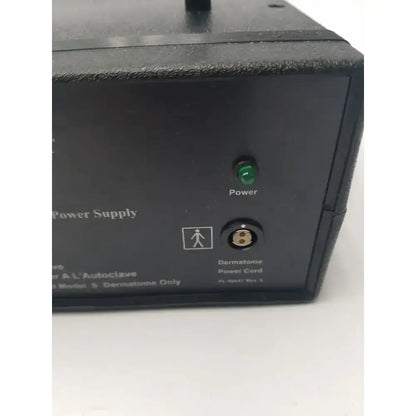 Black integra padgett model s electric dermatome power supply showing green power light and circular power card input port