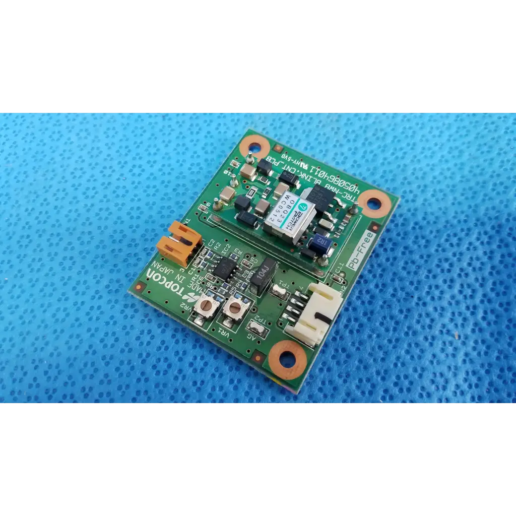 Green rectangular blink control circuit board with electronic components and orange mounting holes for Topcon TRC-NW8 camera
