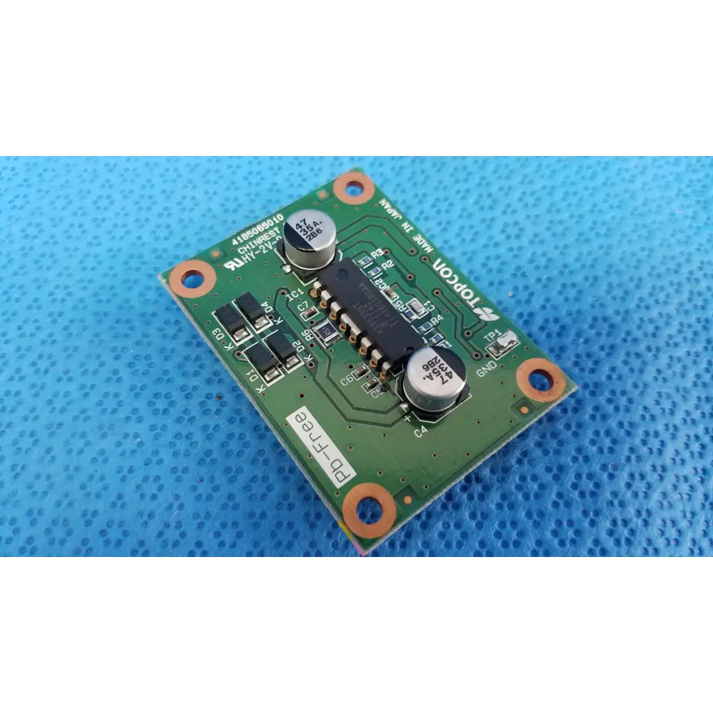 Green printed circuit board with silver capacitors and black integrated circuits featuring topcon branding for chinrest motor driver pcb