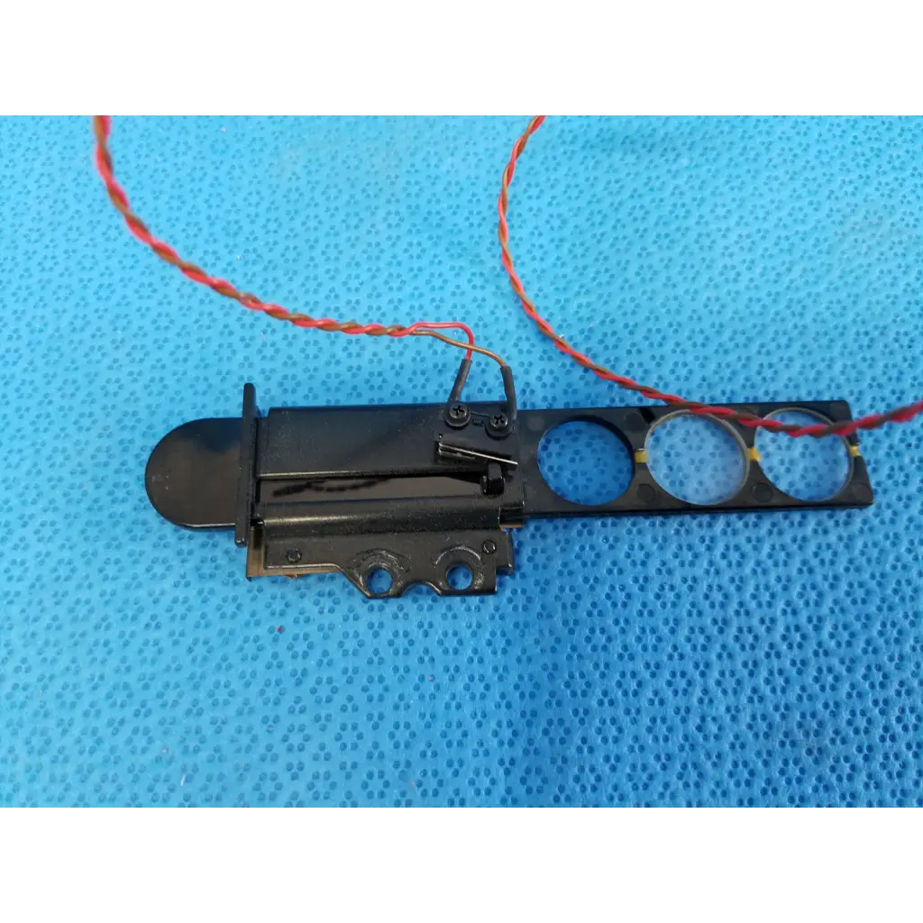 Black plastic and metal internal diopter slider lens assembly with three cutouts and red wire harness for topcon retinal camera