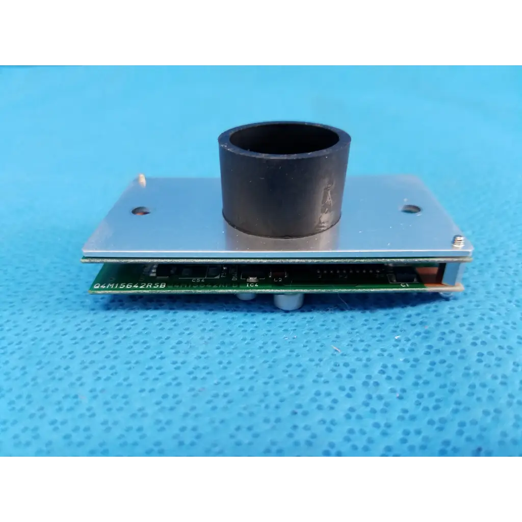 Black cylindrical lens mount on silver metal plate with green circuit board of internal image sensor for retinal camera