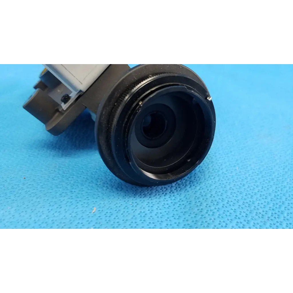 Black main optical lens barrel with matte finish and metallic ring attached to gray housing for topcon retinal camera