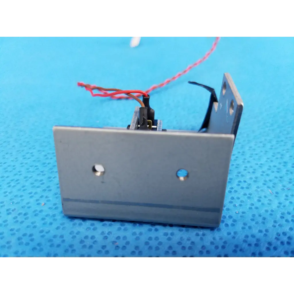 Back side of a silver metallic internal mechanical limit position sensor with black component and wires for topcon fundus camera