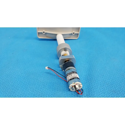 Gray cylindrical micro gear motor with black and white wiring labeled micro co for motorized chinrest assembly