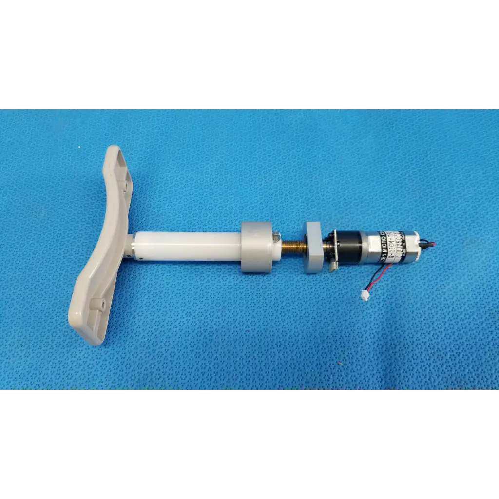 White plastic handle attached to micro gear motor assembly with metallic components for motorized chinrest use