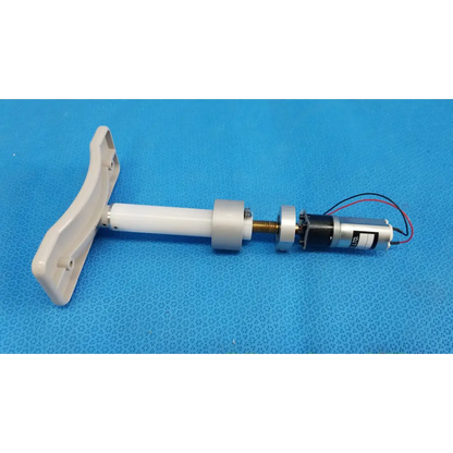 White plastic t-shaped handle attached to a cylindrical internal motorized chinrest micro gear motor assembly with wiring