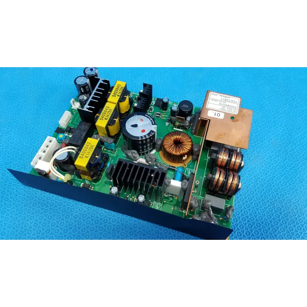 Green power supply board with yellow capacitors copper coils and rotary dial in brown metal enclosure for topcon fundus camera