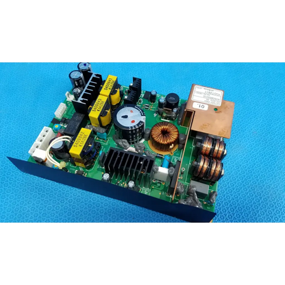 Green power supply board with yellow capacitors copper coils and rotary dial in brown metal enclosure for topcon fundus camera