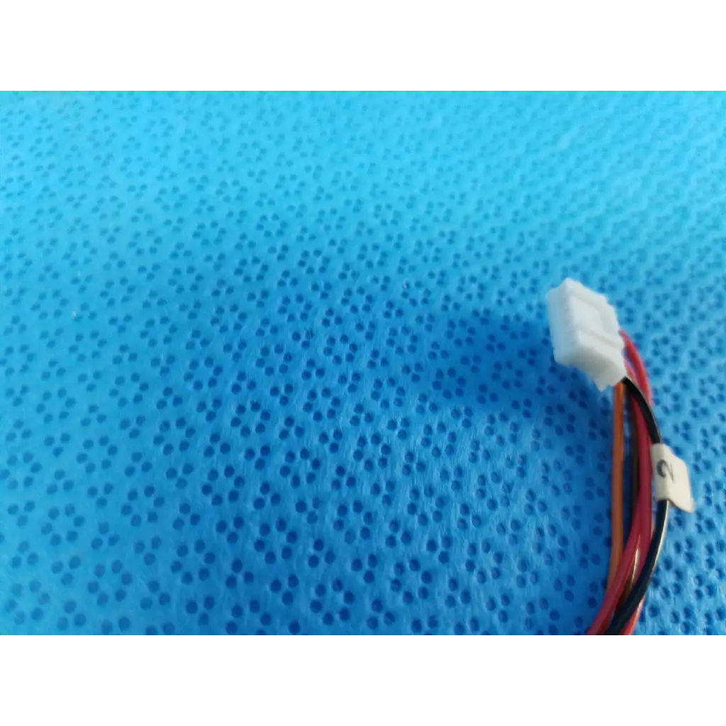 White plastic connector with red and black wires for internal npm stepper motor in trc-nw8 retinal camera