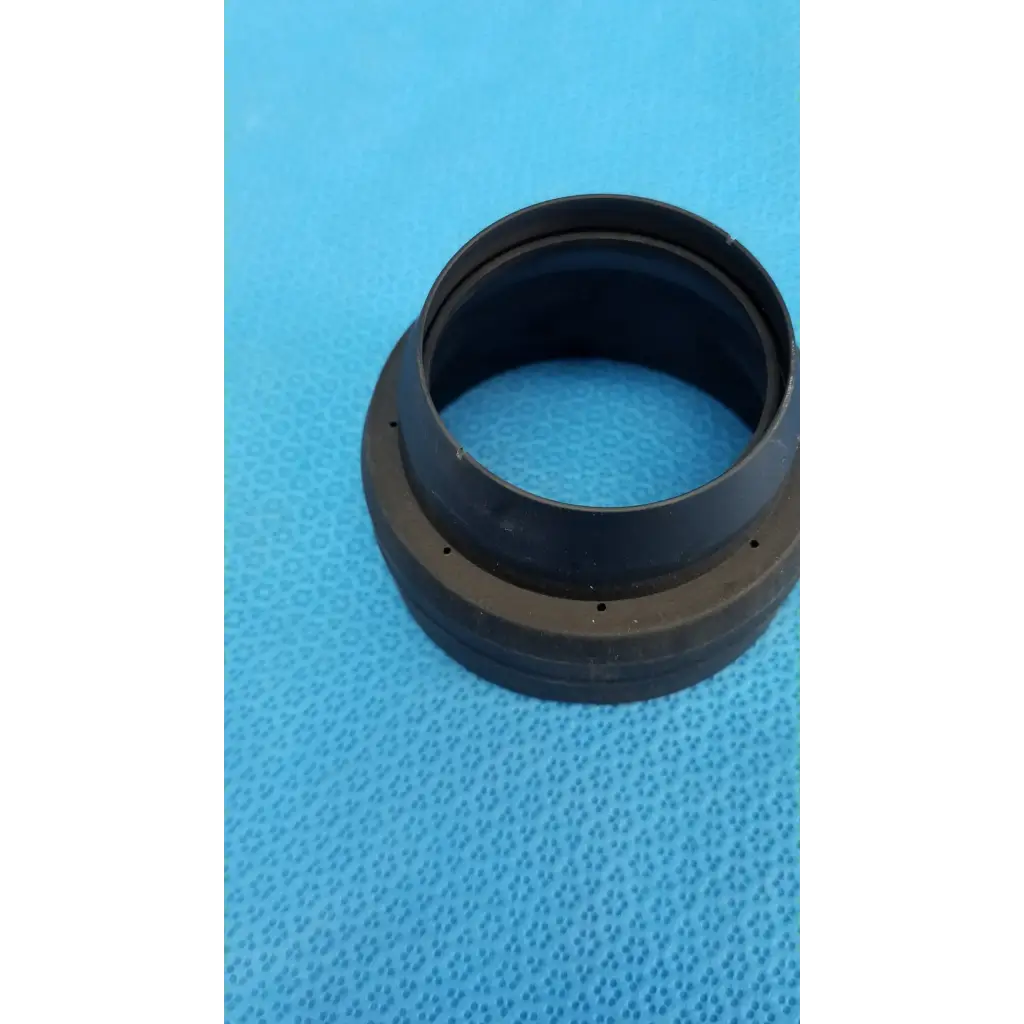 Black rubber dust cap with textured surface and small holes for viewfinder bellows alignment ring in topcon camera set