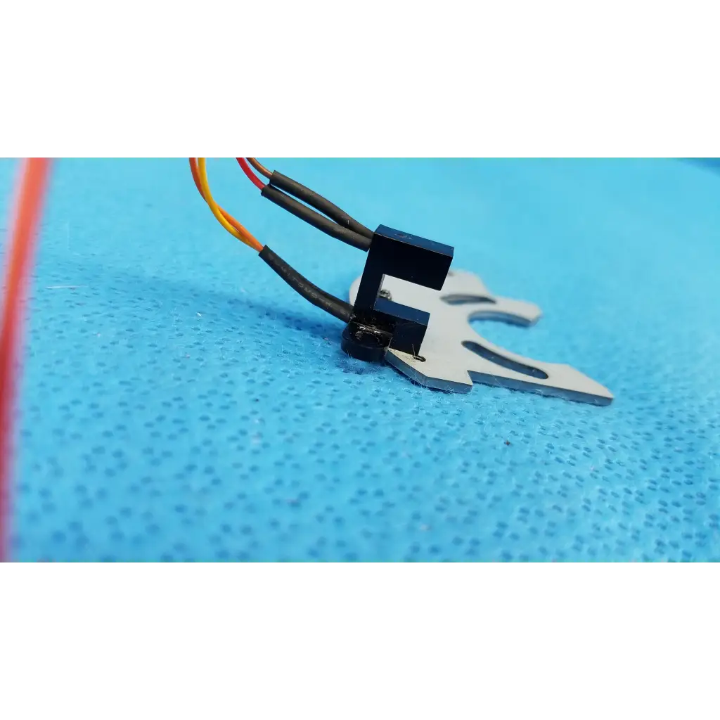 Black and silver optical base axis limit sensor with multi-colored wires and aluminum bracket for topcon fundus camera