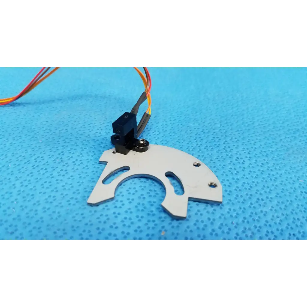 White plastic gear with black motor mount and multi-colored wiring on internal optical base axis limit sensor with aluminum bracket