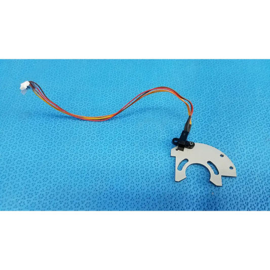 White plastic optical base axis limit sensor with three cutouts and aluminum bracket attached to colorful wire harness