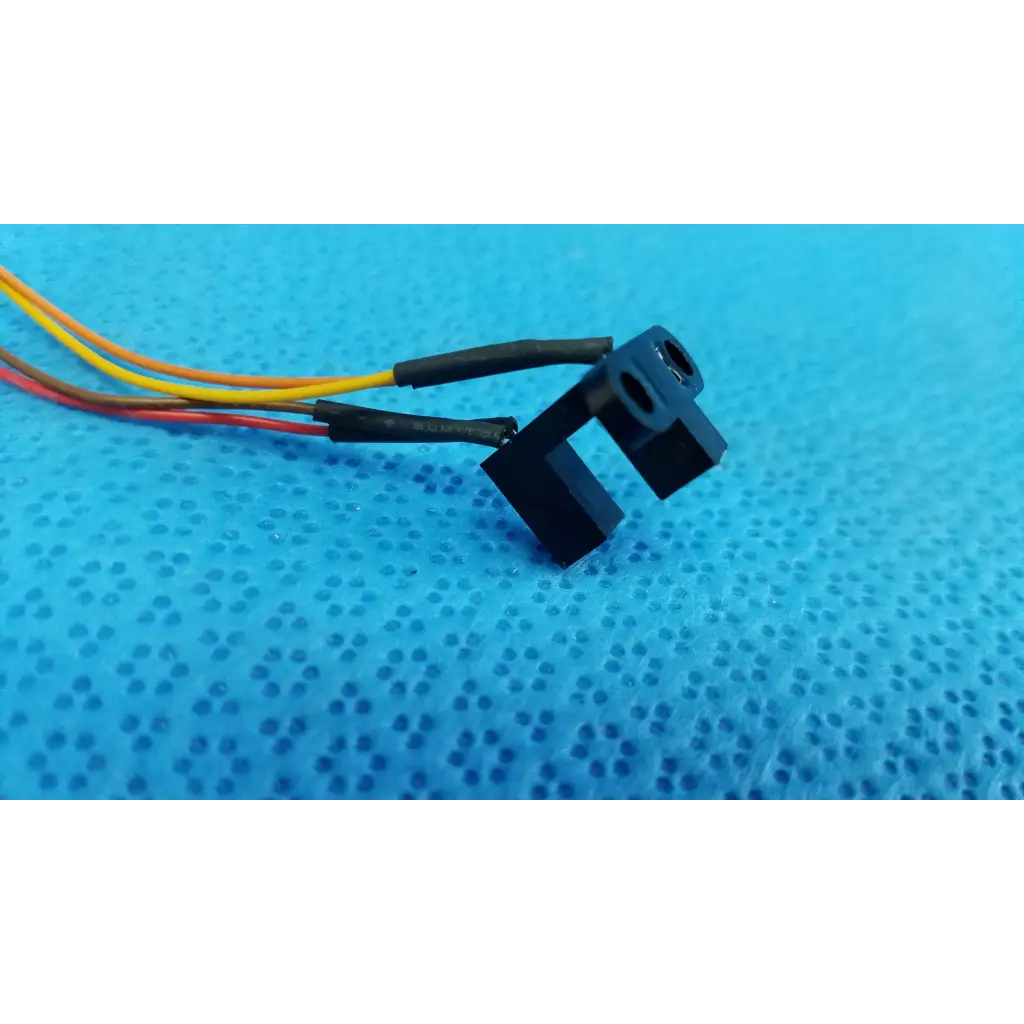 Black plastic internal optical base photo-interrupter sensor with three color-coded wires for sensor wire harness