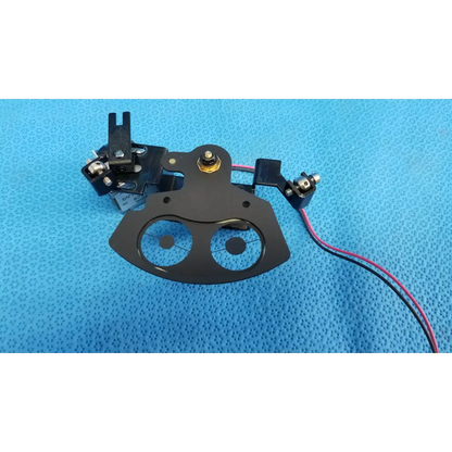Black metal rotary solenoid aperture diaphragm presser foot with circular cutouts and wiring for topcon fundus camera