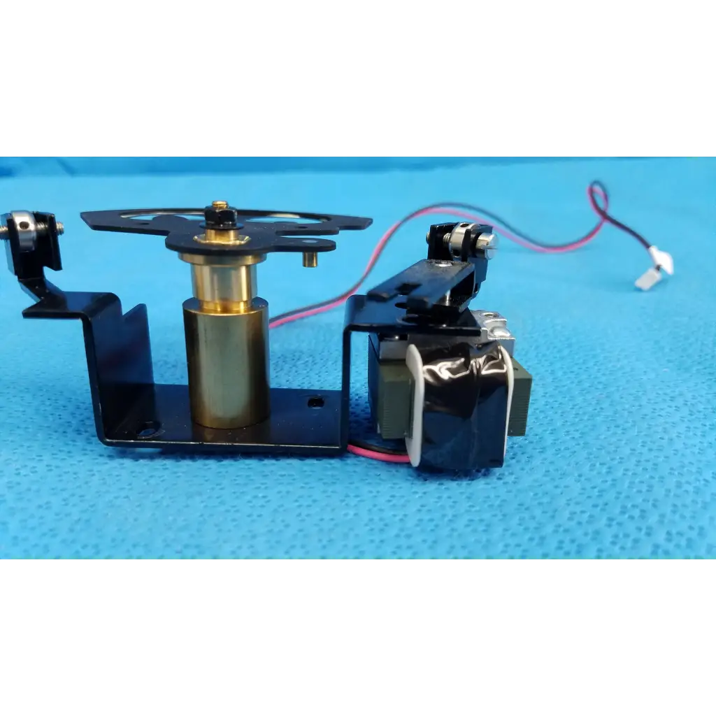 Black and brass rotary solenoid aperture diaphragm with central cylinder mounted on black bracket for topcon fundus camera